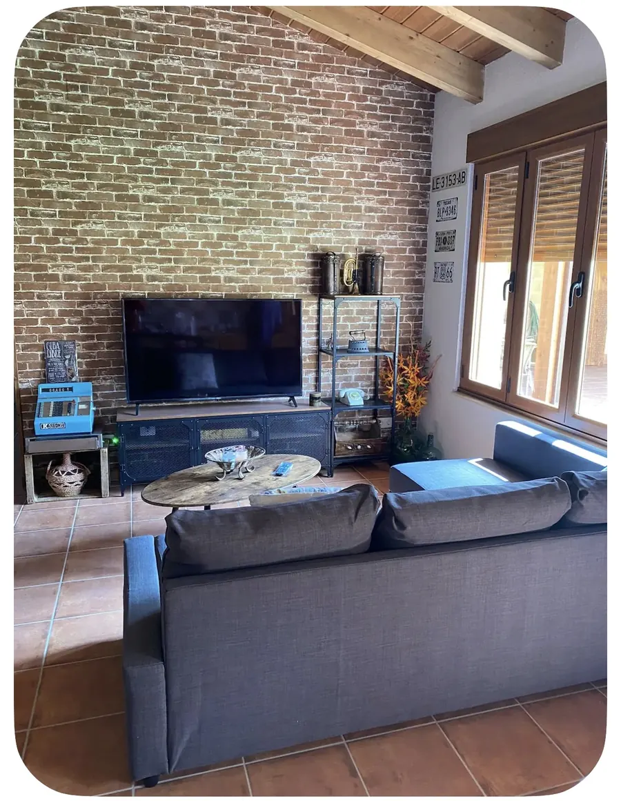 Salón con sofá y pared de ladrillo visto