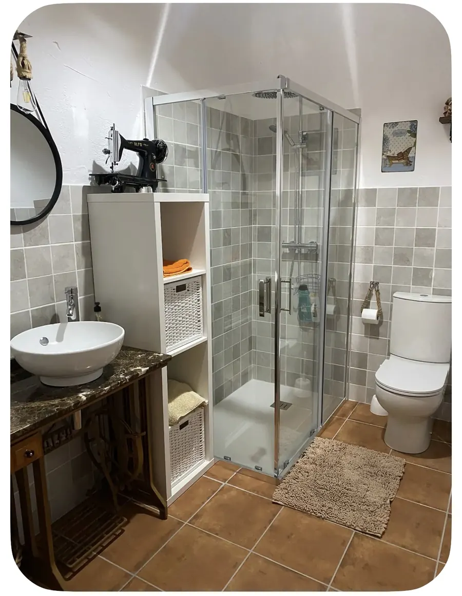 Baño con ducha de obra y mueble reciclado de máquina de coser